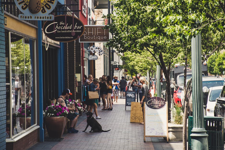 Vibrant city street scene with people shopping and relaxing in a charming downtown area.